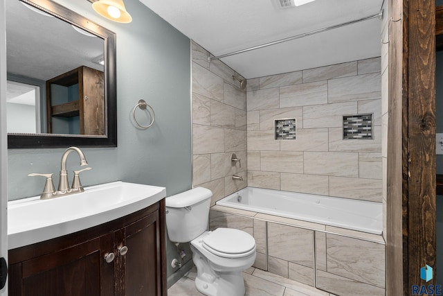 bathroom featuring toilet, tiled shower / bath, and vanity