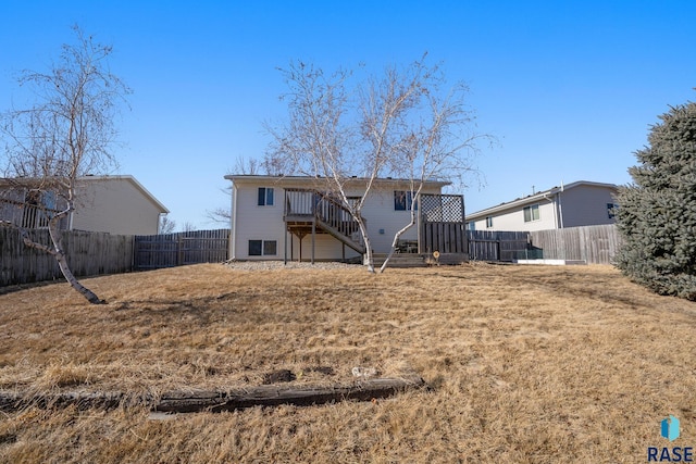 back of property featuring a fenced backyard and stairway