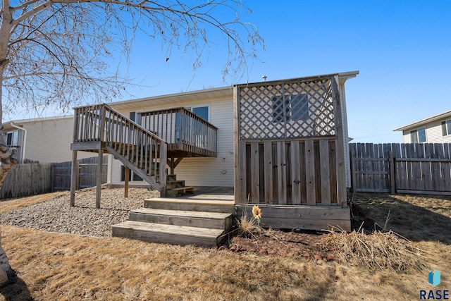 rear view of property featuring stairs, a fenced backyard, and a wooden deck