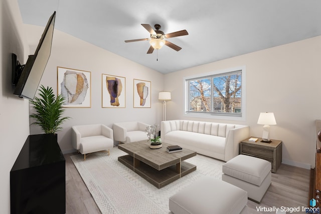 living area with lofted ceiling, ceiling fan, baseboards, and wood finished floors