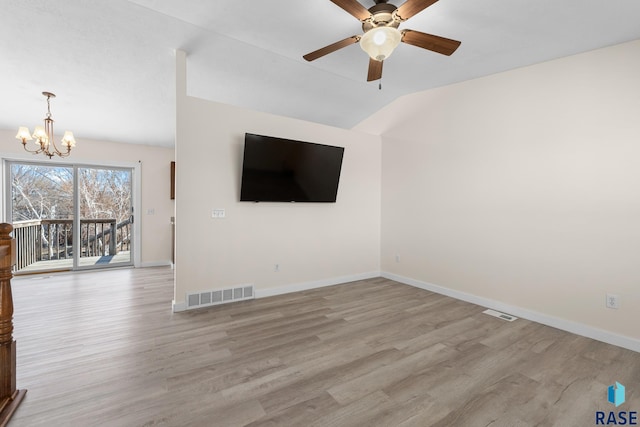 unfurnished living room featuring baseboards, visible vents, vaulted ceiling, and wood finished floors