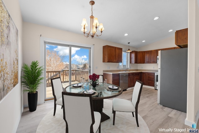 dining area featuring a chandelier, recessed lighting, vaulted ceiling, and light wood finished floors