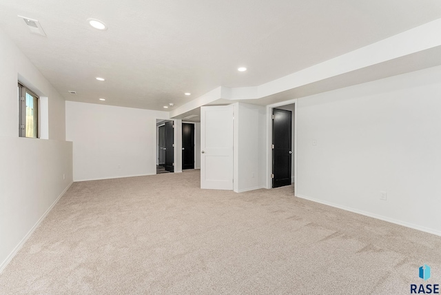 basement featuring recessed lighting, light colored carpet, visible vents, and baseboards