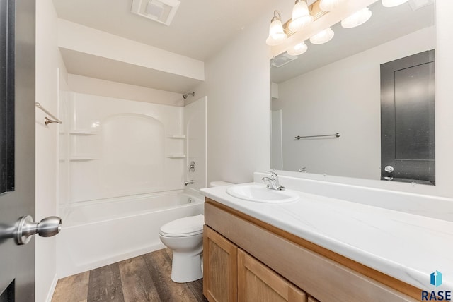 bathroom featuring vanity, wood finished floors, visible vents, shower / washtub combination, and toilet