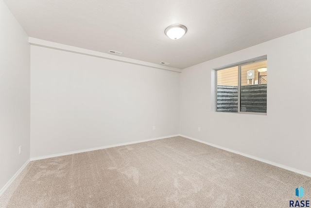 spare room featuring visible vents, baseboards, and carpet floors