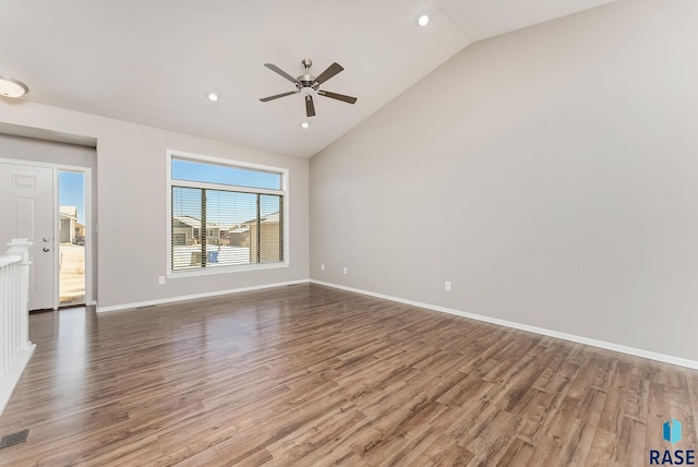 empty room featuring a ceiling fan, vaulted ceiling, wood finished floors, and baseboards