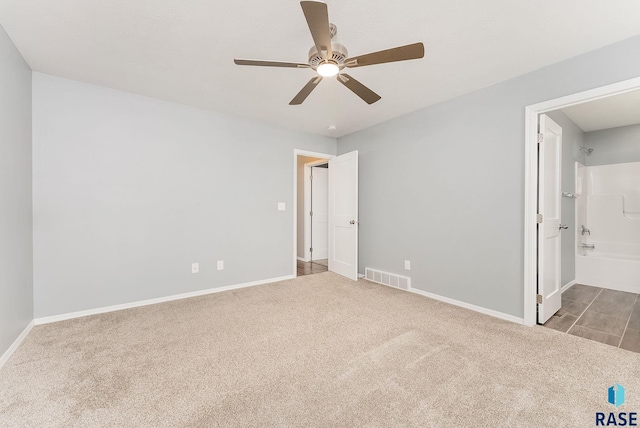 unfurnished bedroom with ensuite bath, carpet flooring, baseboards, and visible vents