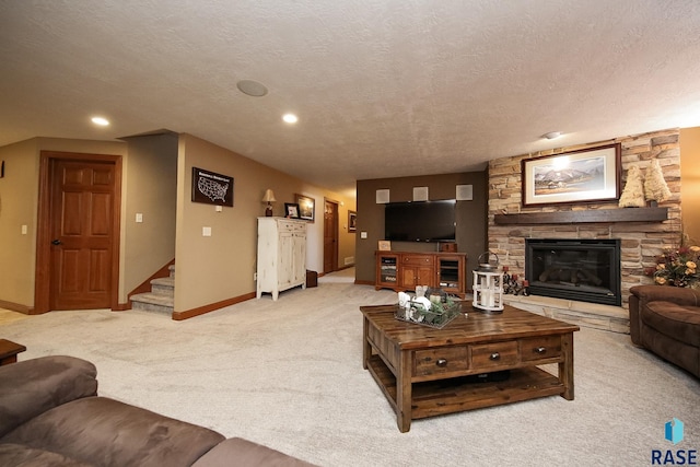 living room with light carpet, baseboards, stairs, a textured ceiling, and a stone fireplace