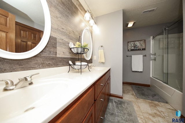 bathroom featuring double vanity, tile patterned flooring, visible vents, and a sink