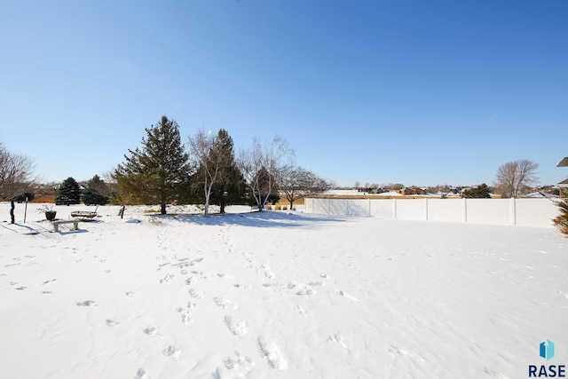 yard covered in snow with fence