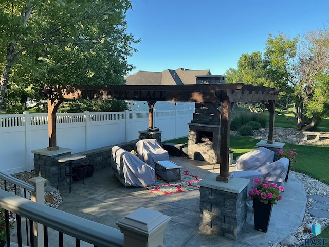 view of patio featuring a fenced backyard, a grill, an outdoor stone fireplace, and a pergola