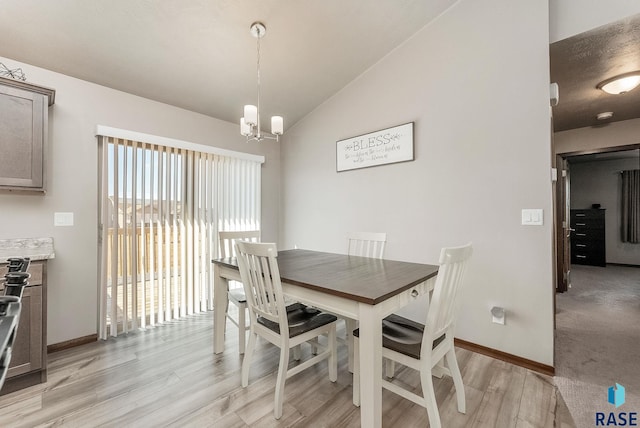 dining space featuring lofted ceiling, light wood finished floors, baseboards, and an inviting chandelier