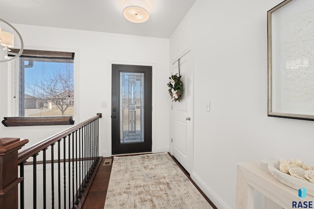 entryway with baseboards and wood finished floors