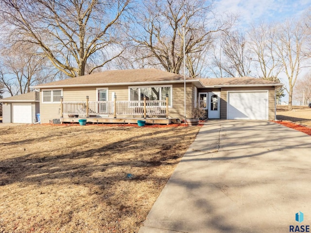 ranch-style home with driveway, an attached garage, and a wooden deck