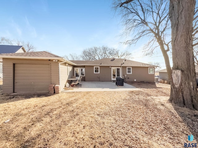 back of house with a garage and a patio area