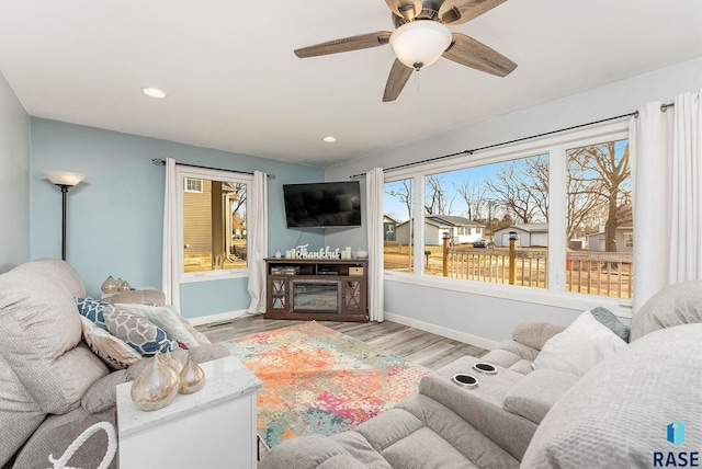 living room featuring recessed lighting, ceiling fan, baseboards, and wood finished floors