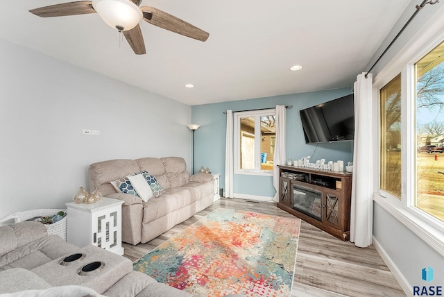 living room with a ceiling fan, recessed lighting, light wood-style flooring, and baseboards