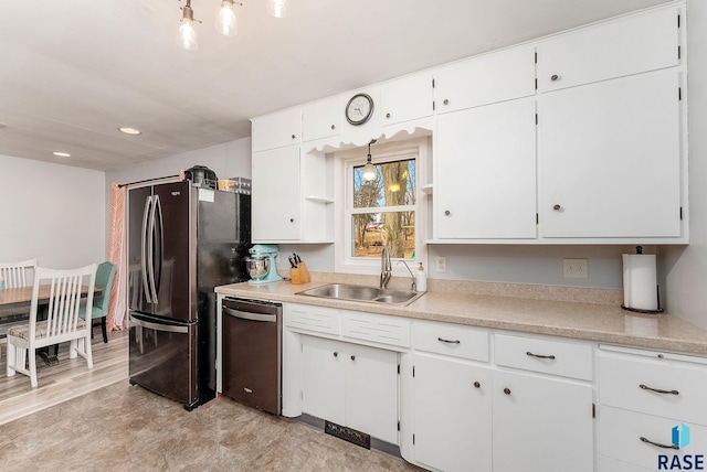 kitchen with appliances with stainless steel finishes, light countertops, white cabinetry, and a sink