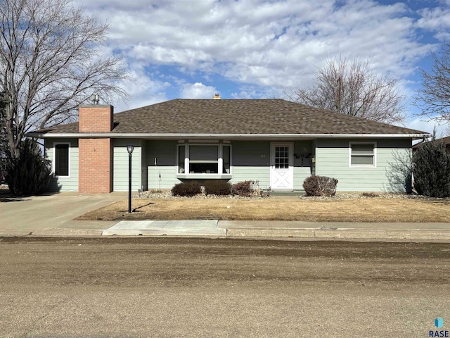 single story home with roof with shingles and a chimney