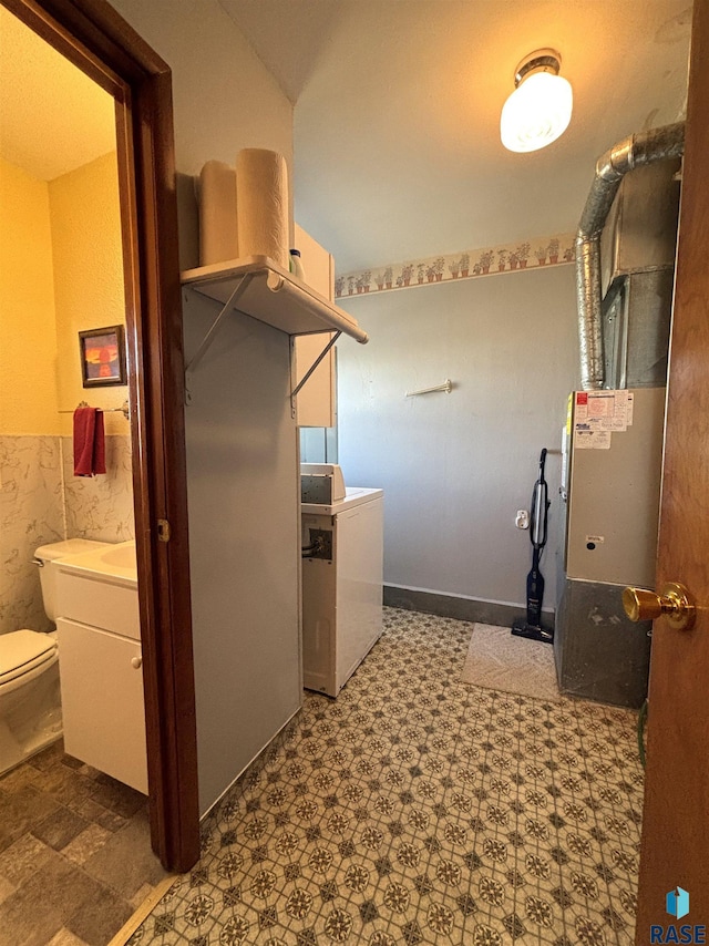 laundry area with laundry area, wainscoting, and tile patterned floors