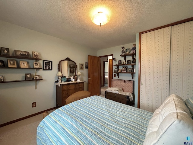 bedroom featuring a textured ceiling, baseboards, and carpet flooring