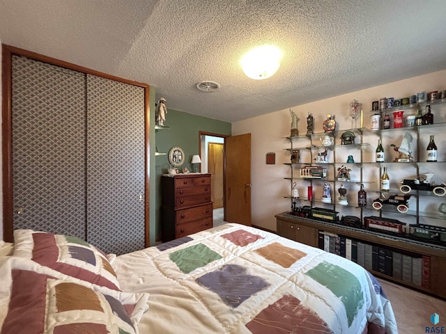 bedroom featuring a textured ceiling and carpet