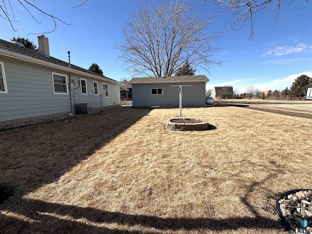 view of yard with central AC and an outdoor structure