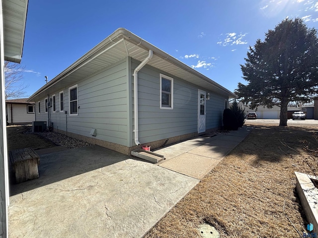 view of side of property featuring a patio area and central AC