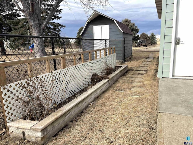 view of side of property with a shed, an outdoor structure, fence, and a gambrel roof