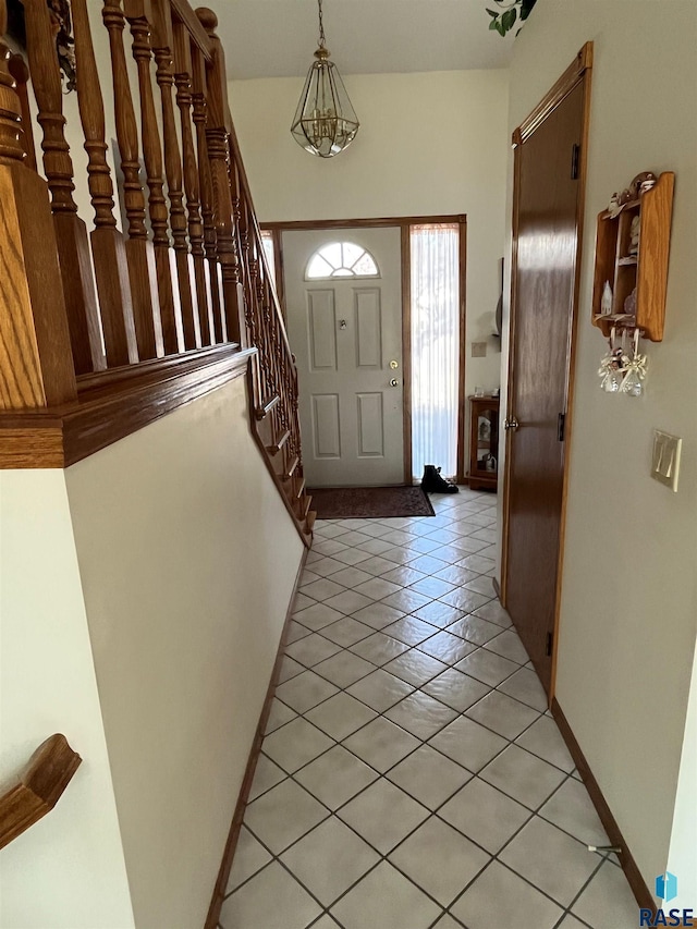 interior space with light tile patterned floors, stairs, and baseboards