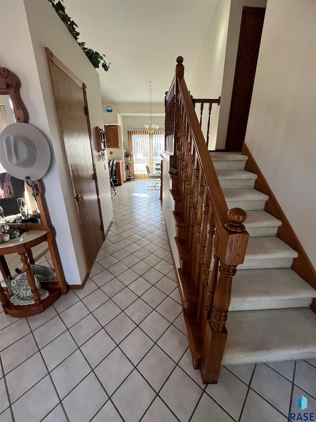 stairway with tile patterned flooring and a chandelier