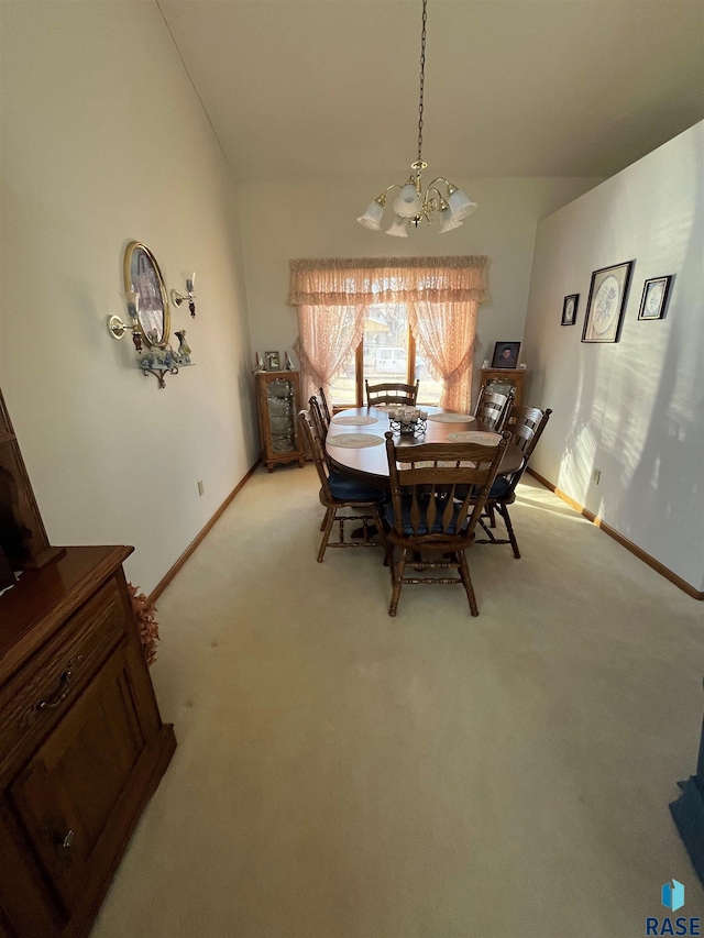 dining room with high vaulted ceiling, light carpet, a notable chandelier, and baseboards