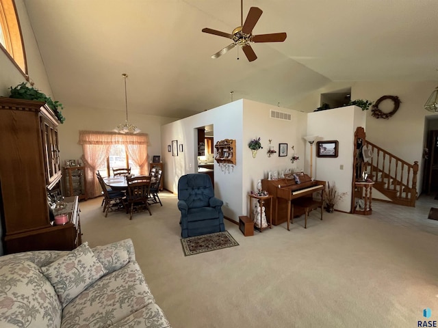 living room with light carpet, visible vents, high vaulted ceiling, and stairway