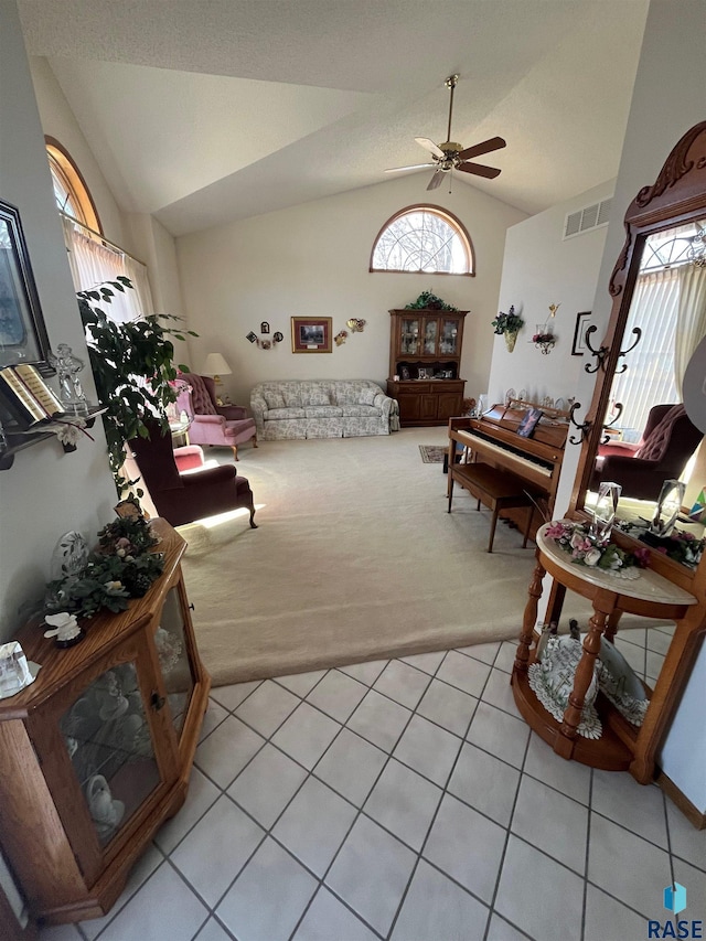 living area with light carpet, a wealth of natural light, visible vents, and lofted ceiling