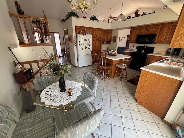 kitchen featuring light tile patterned floors, lofted ceiling, a sink, light countertops, and black appliances