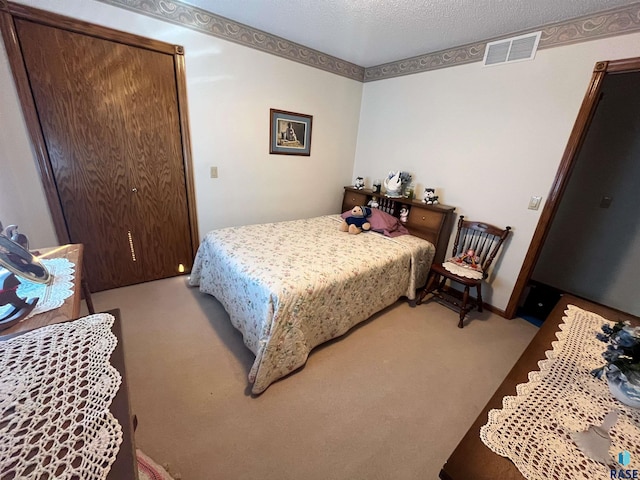 carpeted bedroom with visible vents and a textured ceiling