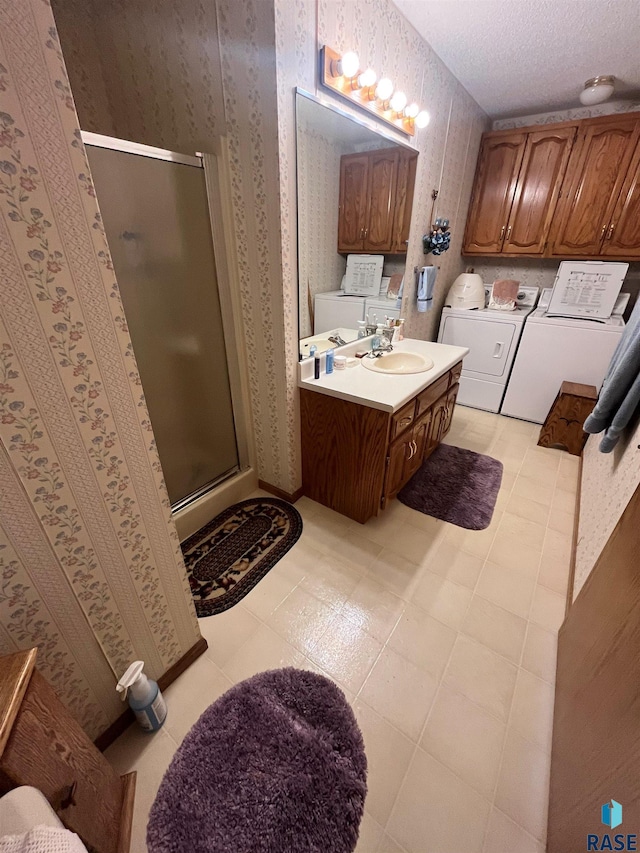 full bath with a stall shower, washing machine and dryer, vanity, and wallpapered walls