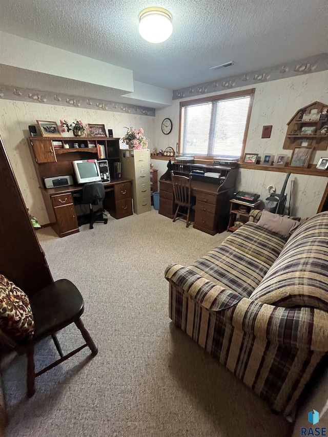 home office with carpet floors, visible vents, and a textured ceiling