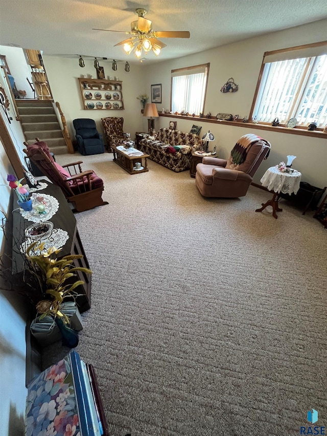 carpeted living room featuring a textured ceiling, stairs, a ceiling fan, and rail lighting