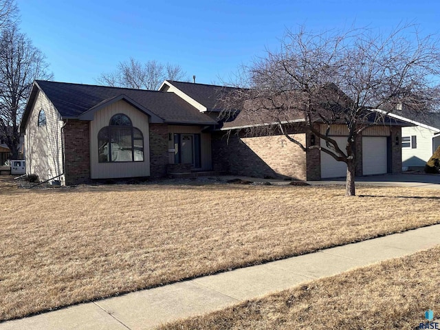 ranch-style house with a garage, brick siding, driveway, roof with shingles, and a front lawn