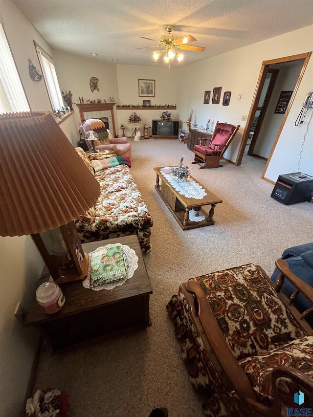 carpeted living room featuring a textured ceiling and a ceiling fan