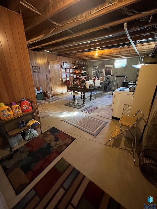 basement with wood walls and washer / dryer