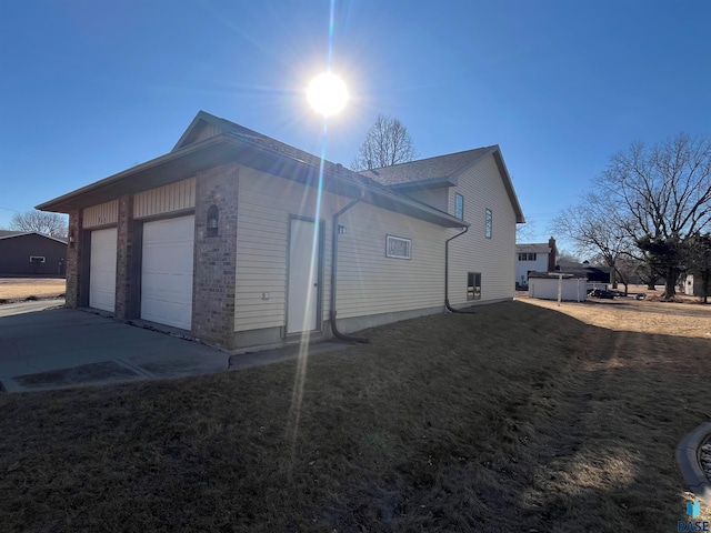 view of side of home with a garage and a lawn