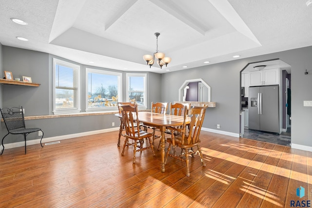 dining area with a raised ceiling and baseboards