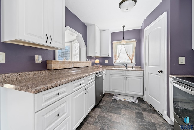 kitchen with white cabinets, stone finish floor, appliances with stainless steel finishes, pendant lighting, and a sink