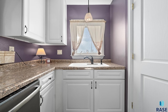 kitchen featuring a sink, white cabinets, stainless steel dishwasher, dark countertops, and decorative light fixtures