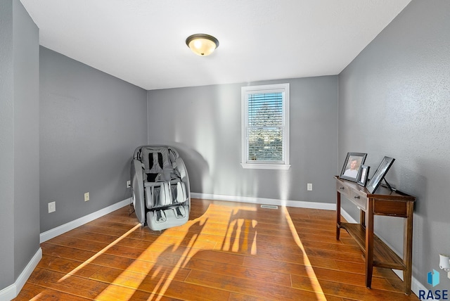 sitting room with baseboards and wood finished floors