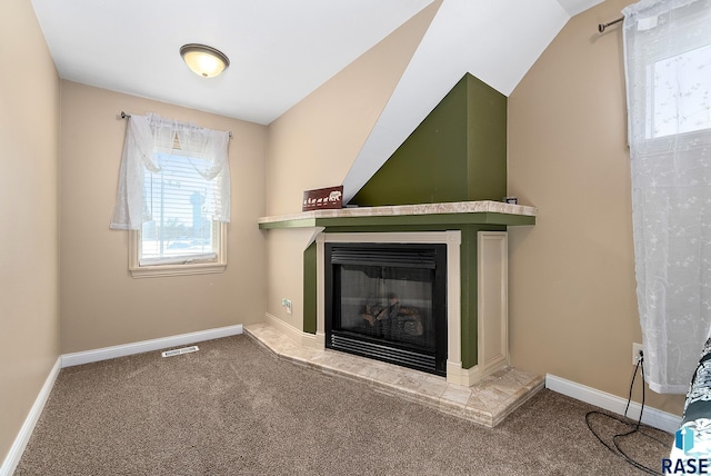 unfurnished living room featuring carpet flooring, a glass covered fireplace, visible vents, and baseboards