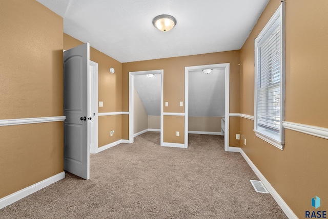 unfurnished bedroom with carpet, visible vents, and baseboards