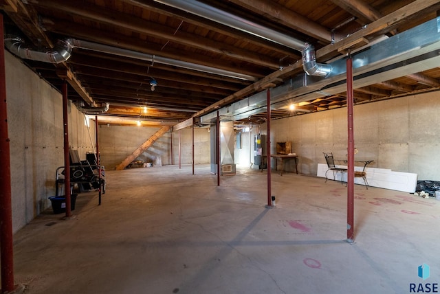 unfinished basement featuring electric water heater